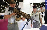Un militaire français tient un fusil d'assaut du fabriquant belge FN Herstal au salon international de défense Eurosatory à Villepinte, près de Paris, le 13 juin 2022
