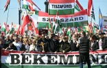 Des manifestants brandissent des drapeaux hongrois, des banderoles et des croix lors d'une marche de soutien au parti Fidesz du Premier ministre hongrois Vitkor Orban, le 15 mars 2026 à Budapest