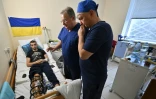 Le chirurgien russe Andreï Volna (g) et Petro Nikitin (d), chef du service de traumatologie, examinent un patient à l'hôpital militaire de Kiev, le 26 janvier 2024 en Ukraine