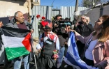 Un Palestinien fait face, drapeau palestinien en main, à des colons israéliens dans le quartier Cheikh Jarrah à Jérusalem-Est, le 13 février 2022
