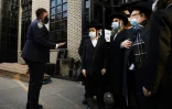 Un policier new-yorkais devant la synagogue de Yetev Lev D'Satmar le 19 octobre 2020, après l'interdiction d'un mariage auquel devaient assister 10.000 personnes dans le quartier de Williamsburg, à Brooklyn