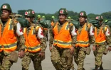 Des membres des forces armées salvadoriennes se préparent à embarquer dans un avion à destination du Venezuela, à la base aérienne de Comalapa, à San Luis Talpa, au Salvador, le 25 juin 2026