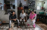 Bipinkumar Padaya (c), son épouse Jaya Padaya (d) et leur fils Darshan Padaya, éligibles à une relocalisation dans le cadre d'un projet de rénovation urbaine, lors d'un entretien avec l'AFP dans leur maison de Dharavi, un bidonville de Bombay, le 8 juillet 2025 en Inde