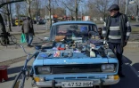 Nikolaï Oskchik, ancien chauffeur professionnel, vend sur le capot de sa voiture Moskvitch datant de l'ère soviétique, un bric-à-brac de pièces de seconde main, à Mykolaïv, dans le sud de l'Ukraine, le 22 mars 2022