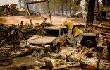 Une voiture brûlée par le Park Fire, dans le village de Paynes Creek en Californie, le 26 juillet 2024