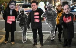 Des manifestants portent des masques du président Yoon Suk Yeol et du chef de file du parti au pouvoir au Parlement Choo Kyung-ho, le 6 décembre 2024 devant l'Assemblée nationale à Séoul 