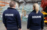 Des douaniers devant des colis de fret aérien dans un entrepôt de l'aéroport de Roissy-Charles de Gaulle, au nord de Paris, le 29 avril 2025