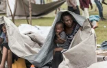 Une femme et un enfant réfugiés du séisme d'Haïti tentent de se protéger de la pluie, près de la ville des Cayes, le 17 août 2021