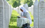 Une musulmane bosniaque lit un livre de prières au milieu des pierres tombales de proches tués lors du massacre de Srebrenica (Bosnie-Herzégovine) en 1995, au cimetière du Mémorial de Srebrenica à Potocari, le 8 juin 2021