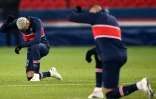 Neymar (à gauche) et Kylian Mbappé genou à terre contre le racisme avant la reprise du match de Ligue des champions du Paris SG contre Basaksehir Istanbul le 9 décembre 2020 au Parc des Princes