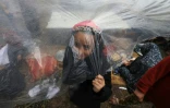 Une jeune Palestinienne se tient à l'intérieur d'une tente au milieu de la pluie dans un camp pour personnes déplacées de Rafah, dans le sud de la bande de Gaza, le 12 décembre 2023