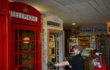 Carl Burge travaille sur une cabine téléphonique dans son atelier "Remember When UK" à King's Lynn, le 11 août 2023 dans l'est de l'Angleterre