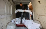 Un Palestinien transporte le corps d’un enfant dans une camionnette contenant les dépouilles d'autres personnes tuées lors de frappes aériennes israéliennes, dans l’enceinte de l’hôpital Al-Ahli Arab de Gaza-Ville, le 21 mai 2025