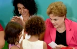 La présidente du Brésil Dilma Rousseff salue des enfants lors d'une rencontre Femmes en défense de la démocratie à Brasilia le 7 avril 2016