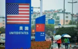Des panneaux avec les drapeaux américain et chinois devant un magasin vendant des produits étrangers à Qingdao, le 19 septembre 2018 en Chine