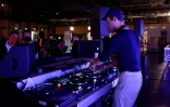 Un DJ s'affaire sur sa table de mixage alors que des personnes attendent pour être vaccinées contre le Covid-19 le 9 août 2021 au club Arena de Berlin 