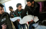 Des Syriens transportent le corps d'un enfant tué lors d'une frappe aérienne à Hamouria près de Damas au cours de laquelle au moins 16 civils sont morts et des dizaines de personnes ont été blessées, le 25 mars 2017