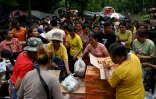 Des déplacés cambodgiens ayant fui les combats avec la Thaïlande reçoivent de la nourriture près de la frontière le 27 juillet 2025 