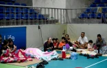 Des habitants abrités dans un gymnase à Vinh, ville côtière de la province de Nghe An, avant l'arrivée du typhon Kajiki, le 25 août 2025 au Vietnam
