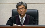Capture d'image d'une vidéo du tribunal du district central de Séoul montrant le juge Kim Se-yoon lisant le verdict condamnant l'ex-présidente sud-coréenne Park Geun-hy à 24 ans de prison pour corruption, le 6 avril 2018