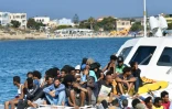 Des migrants en provenance de Tunisie et de Libye arrivent à Lampedusa à bord d'un bateau des gardes-côtes italiens, le 1er août 2020