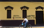 Un homme passe à bicyclette devant des inscriptions "Ortega assassin" et "Notre lutte est juste", dans la ville de Masaya, le 20 juin 2018