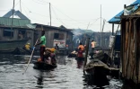Des habitants se déplacent en pirogue, dans le bidonville flottant de Makoko, à Lagos, le 23 octobre 2019 au Nigeria