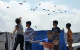 Un enfant montre du doigt un largage aérien d'aide humanitaire à Rafah, dans le sud de la bande de Gaza, le 2 août 2025 
