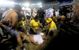 Des sauveteurs s'occupent d'un blessé après une bousculade pendant un match de football entre Alianza et FAS au stade Cuscatlan, le 20 mai 2023 à San Salvador