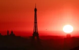 Le soleil se lève derrière la Tour Eiffel, à Paris, le 1er juillet 2025 en période de canicule