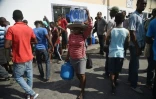 Des habitants de Port-au-Prince font la queue pour des bouteilles de gaz et des bidons d'eau, le 16 février 2019 en Haïti