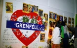 Des personnes se recueillent devant les photos des victimes de l'incendie de la Tour Grenfell, le 13 juin 2018