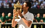 Le Serbe Novak Djokovic embrasse le trophée après avoir remporté Wimbledon aux dépens du Sud-Africain Kevin Anderson, le 15 juillet 2018