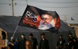 Des pèlerins chiites brandissent un portrait de l'ayatollah Ali Khamenei, le guide suprême iranien tué au début de la guerre, le 19 juin 2026 à Bassorah, en Irak