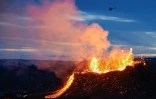 Un hélicoptère survole une coulée de lave en fusion  près du mont Fagradalsfjall, à une quarantaine de kilomètres de Reykjavik, le 6 avril 2021 en Islande