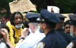 Des manifestants crient sur des policiers lors d'une manifestation contre le racisme, à New York, le 28 mai 2020