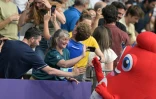 Des supporters avec la mascotte des JO "Phryge" au Stade de France le 25 juillet