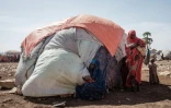 Une femme de 28 ans porte son enfant de un an et demi dans le camp de déplacés de Muuri à Baidoa (Somalie), le 13 février 2022