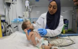Un enfant palestinien souffrant de malnutrition est soigné par une infirmière à l'hôpital Nasser de Khan Younès, dans le sud de la bande de Gaza, le 10 juillet 2024