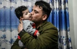 Hamid Safi, un chauffeur de taxi, embrasse Sohail Ahmadi qu'il avait trouvé à l'aéroport de Kaboul dans le chaos des évacuations en août 2021 et dont il a cherché la famille, chez le grand-père du garçon à Kaboul le 9 janvier 2022