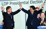 Le Premier ministre japonais Shinzo Abe (D) après sa réélection à la tête de son Parti libéral-démocrate, aux côtés de son rival Shigeru Ishiba, à Tokyo le 20 septembre 2018