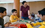 Tariq Pervez, patron de la section jeunesse de la Fédération pakistanaise de Scrabble, enseigne le Scrabble à des enfants lors d'un tournoi, le 16 février 2025 à Karachi