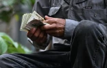 Un vendeur de bétail compte son argent après avoir conclu une vente au Marché municipal du bétail de Sensuntepeque, dans le département de Cabañas, au Salvador, le 1er octobre 2026