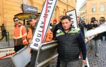 Des agriculteurs brandissent des panneaux de sortie de ville lors d'une manifestation contre les  "réglementations incohérentes" et l'accord commercial UE-Mercosur devant l'hôtel de ville de Metz, le 29 novembre 2024.