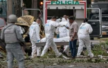 Des policiers portent le corps d'une victime morte dans une explosion à Cali, en Colombie, le 21 août 2025
