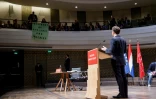Des étudiants déploient une banderole sur laquelle il est écrit "Pésident de la violence et de l'hypocrisie" pendant le discours d'Emmanuel Macron à La Haye, le 11 avril 2023