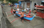 Des habitants de Legaspi City, province d'Albay, au sud de Manille, mettent une embarcation à l'abri avant l'arrivée du typhon Kammuri
