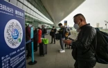 Des voyageurs attendent de passer les contrôles à leur arrivée à l'aéroport de Wuhan, le 11 avril 2020 dans la province chinoise du Hubei