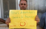 Un Chrétien irakien réfugié dans le vilage Ankawa au nord d'Erbil, capitale du Kurdistan irakien, avec un panneau montrant le symbole des Chrétiens d'Orient, la lettre arabe "N" le 12 septembre 2014