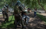 Des policiers arrêtent un manifestant durant des affrontements à Santiago, le 20 octobre 2019